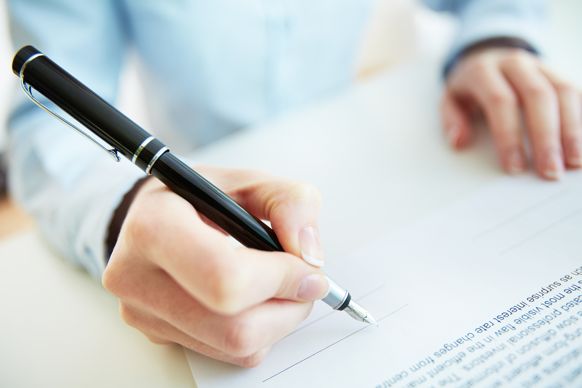 Close-up image of a business woman being to put her signature